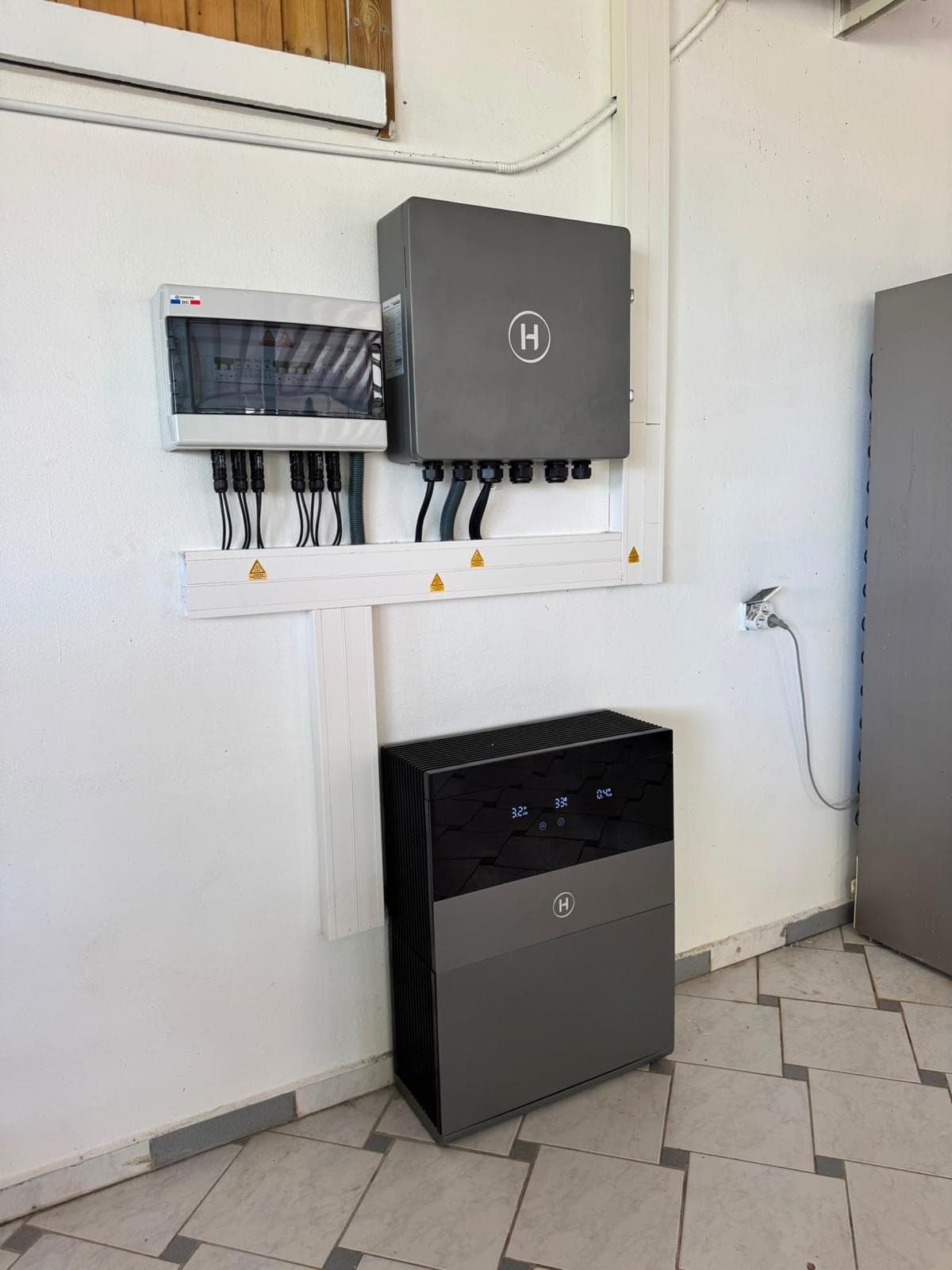Onduleur hybride et batterie installés dans un local technique